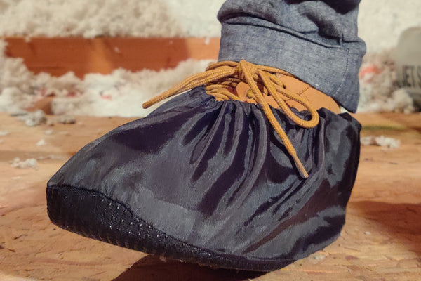 Black reusable shoe cover over a work boot